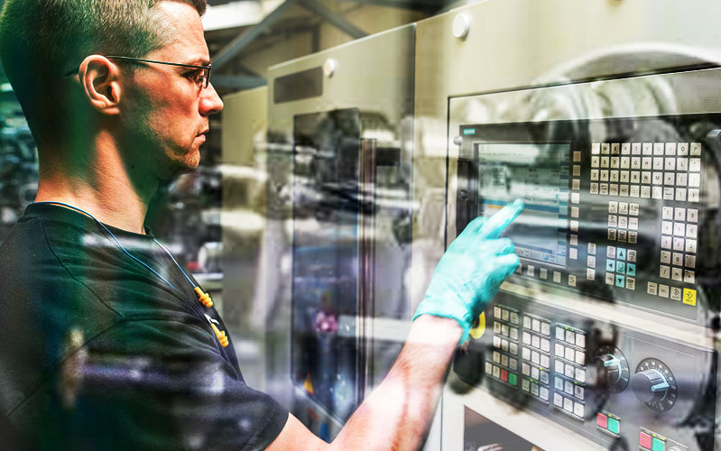 Technician operates CNC machine at ASC facility